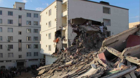 Ağır hasarlı bina yıkım esnasında yan binanın üzerine devrildi