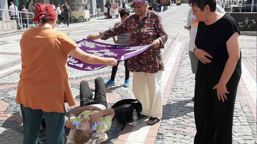 Kadınlar yerde yatan yaralıyı örtü ile güneşten korudu