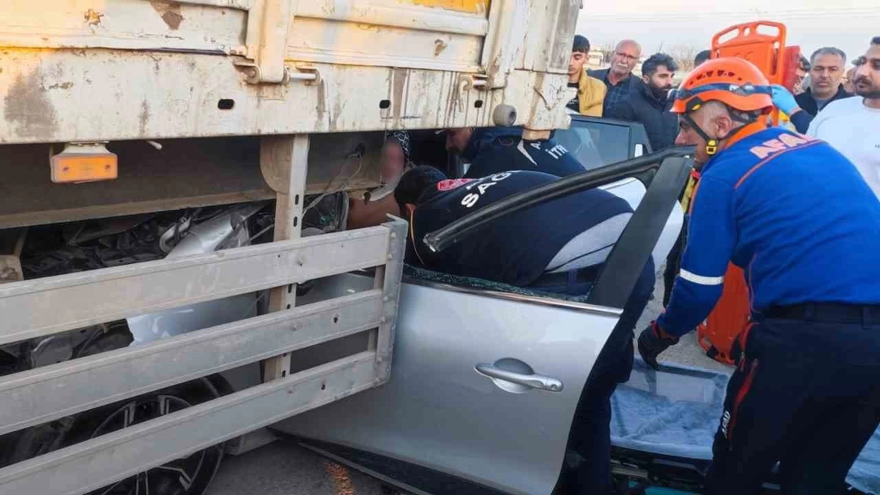 Otomobil park halindeki tırın altına girdi