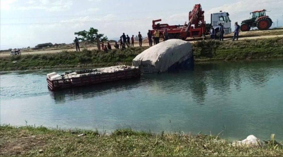 Tar�m i��ilerini ta��yan trakt�r sulama kanal�na d��t�