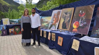 Ressam çift resimlerini köy meydanında sergiledi