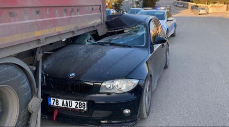 Otomobil park halindeki tırın altına girdi