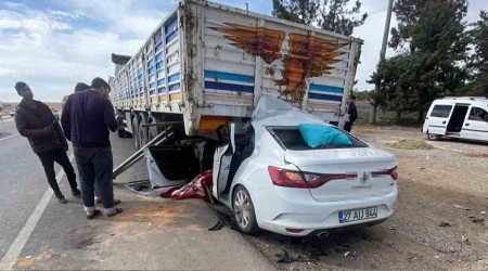 Otomobil park halindeki tırın altına girdi