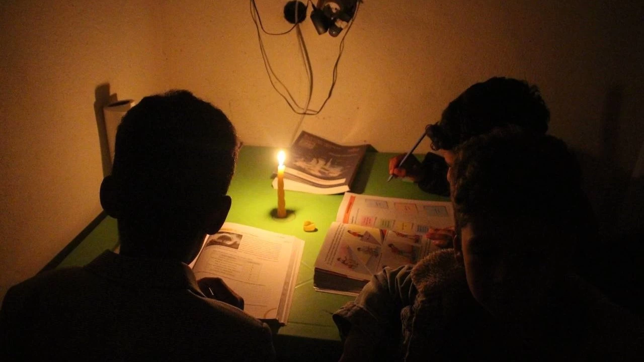 Öğrenciler mum ışığında ders çalışıyor