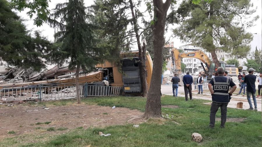 Hasarlı bina yıkımı esnasında iş makinesi devrildi