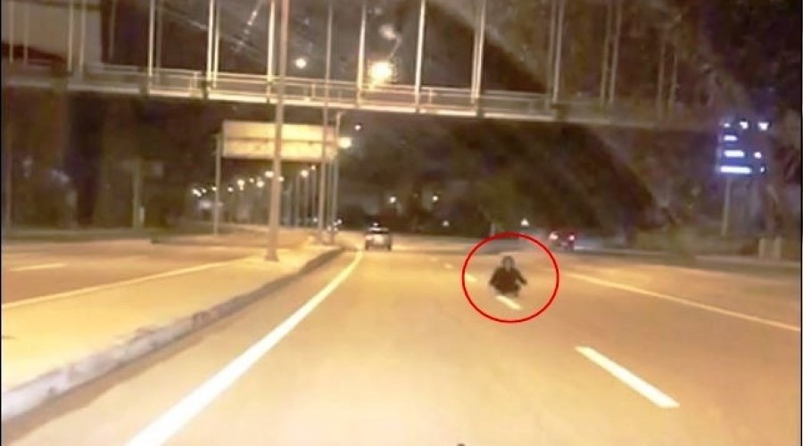 Otoyolda yol ortasna oturan kadn, lme davetiye kard