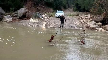 Derenin debisi yükselince aracıyla mahsur kaldı